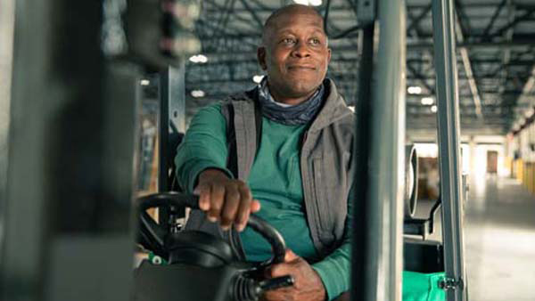 Forklift Operator Smiling and Looking Left while he steers