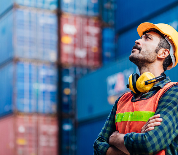 Dockworker next to Container Shipping Boxes